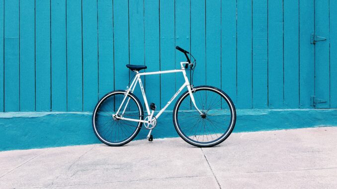 Ein weißes Fahrrad vor einer blauen Wand