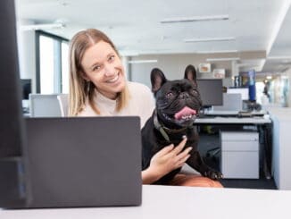 Frau mit Hund am Schreibtisch