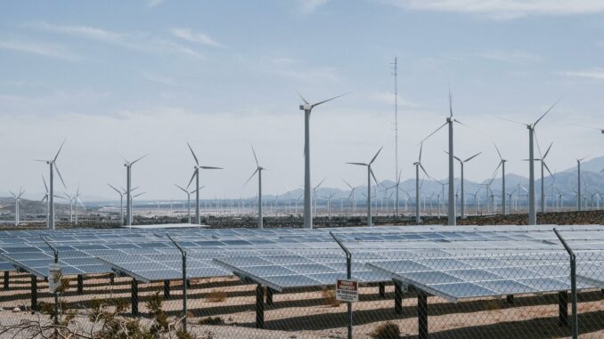 Zu sehen sind Photovoltaik-Anlagen sowie Windräder. © Pexels