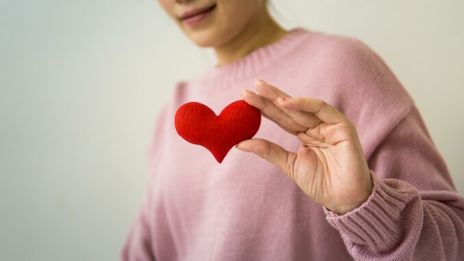 pexels-puwadon-sang-ngern-2168173-5340276 Zu sehen ist eine Person, die ein rotes Herz in die Kamera hält.