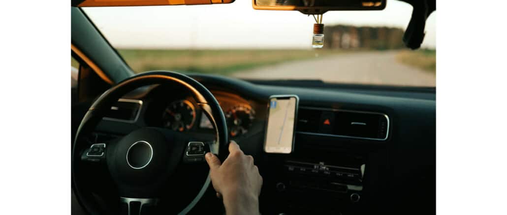 Zu sehen ist eine Person, die Auto fährt. Man sieht den Innerazm, Lenkrad sowie das Armaturenbrett.