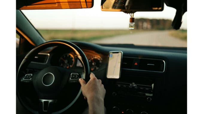 Auto Zu sehen ist eine Person, die Auto fährt. Man sieht den Innerazm, Lenkrad sowie das Armaturenbrett.