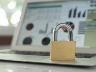 Ein Sicherheitsschloss steht im Fokus auf einem aufgeklappten Laptop. Auf dem Laptop-Bildschirm, der unscharf im Hintergrund zu sehen ist, werden Daten angezeigt. Austriacard schafft mit seiner neuen KI-Lössung Datensicherheit. ©Envato Elements / akportfolio24