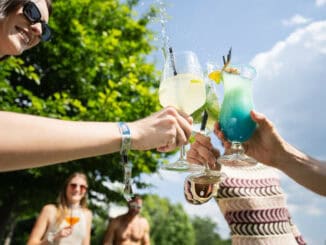Mehrere Personen stoßen mit Cocktails an.